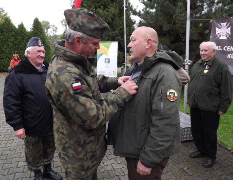 Wielokrotny mistrz Polski i instruktor strzelecki Robert Wrona odznaczony okolicznościowym Medalem przez prezesa LOK płka Jerzego Salamuchę. Z lewej: ppłk rez. Ryszard Kasprzyk. Z prawej wiceprezes Śl.OW LOK w Katowicach Stanisław Kowarczyk.