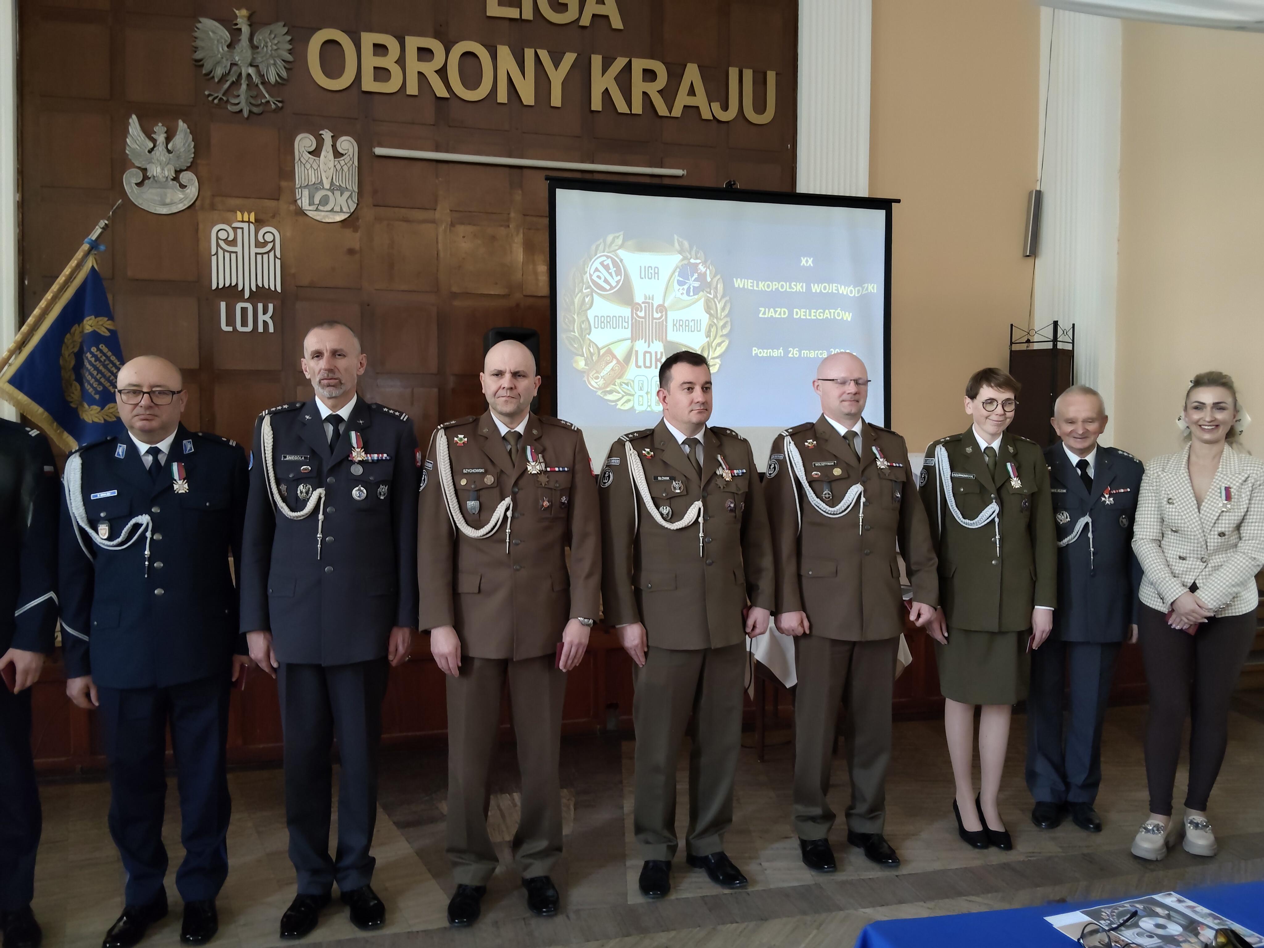 od lewej insp. Bogdan Ginalski Ekspert WPA, płk Radosław Śniegóła Z-ca Dowódcy 31. Bazy Lotnictwa Taktycznego, ppłk Mirosław Szychowski Z-ca Dowódcy 12. Wlkp. Brygady Obrony Terytorialnej, ppłk Krzysztof Słowik Szef Sztabu Brygady, mjr Damian Wolsztyniak Szef Sekcji Szkolenia Brygady, ppor. Katarzyna Antkowiak Oficer Sekcji Komunikacji Społecznej Brygady, płk Janusz Chwiejczak Prezes LOK, Izabela Bagrowska Sekretarz WZW LOK Poznań. 